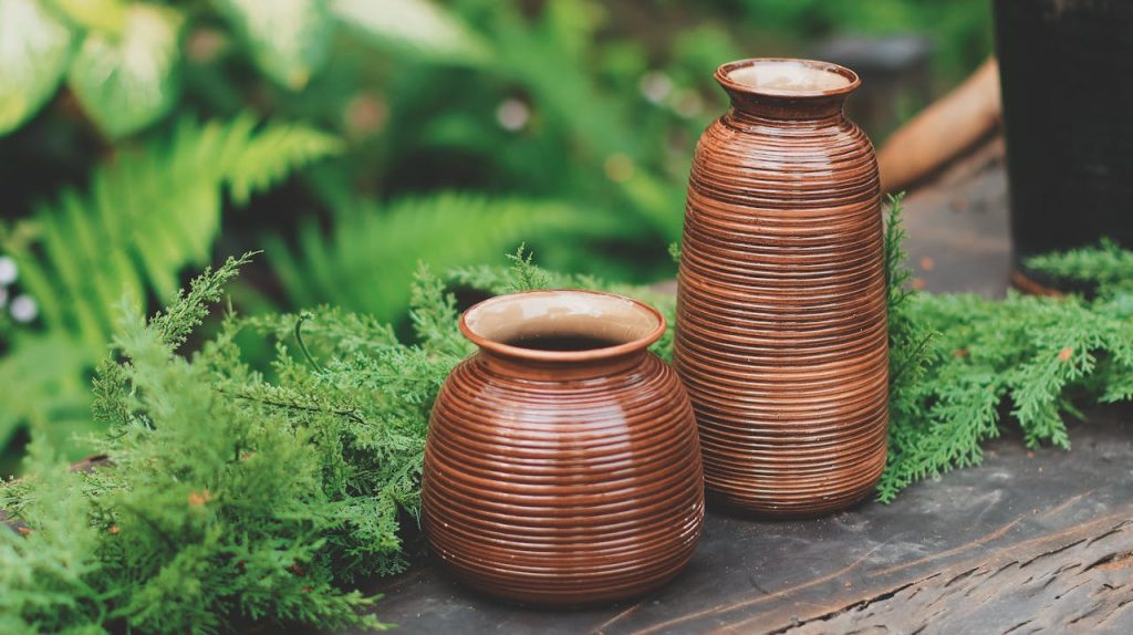 Doğal ahşap konsol üzerinde sergilenen el yapımı Bali Decor seramik vazo ve tropikal dekorasyon.